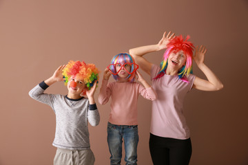 Family in funny disguise on color background. April fools' day celebration