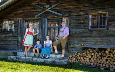 Young Bavarian family in a beautiful mountain landscape. Happy parents and smiling kids in...