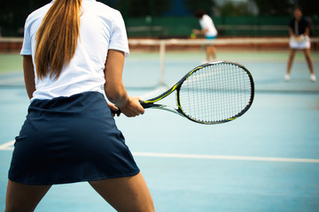 Young happy woman playing tennis at tennis court