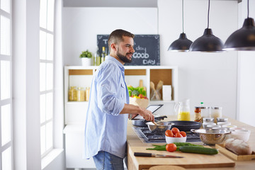 Smiling and confident chef standing in large kitchen