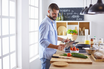 Smiling and confident chef standing in large kitchen