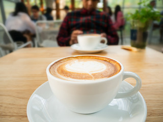 Cup of latte art coffee on table in the coffee shop