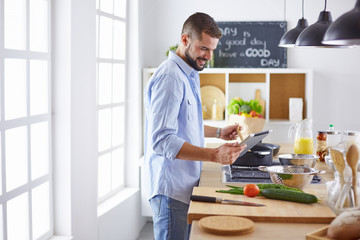 Smiling and confident chef standing in large kitchen