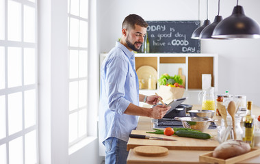 Smiling and confident chef standing in large kitchen