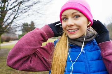 Teenage sporty girl listening to music outdoor.