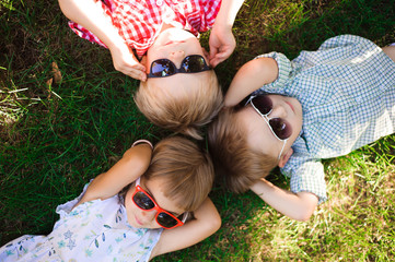 Smiling kids at the garden in sunglasses
