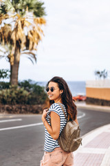 Pretty long hair tourist girl walking on the street.