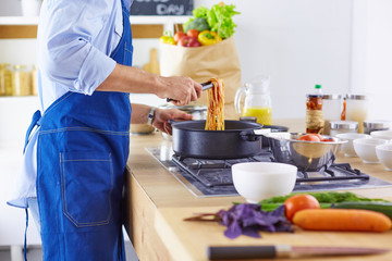 Smiling and confident chef standing in large kitchen