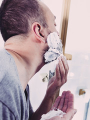 Man applying shaving cream on beard