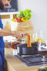 Smiling and confident chef standing in large kitchen