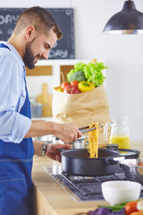 Smiling and confident chef standing in large kitchen