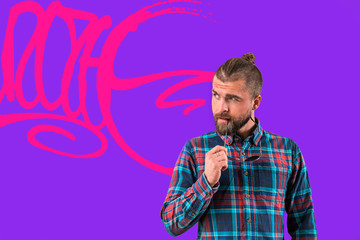 Handsome stylish man is standing near wall.