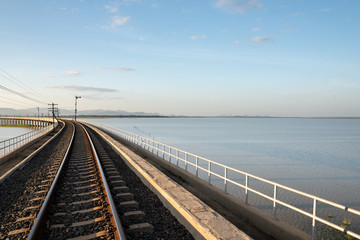 Landscape View of Train crossing Pasak Chonlasit Dam. Reservoir for agriculture at Lopburi,Thailand