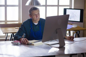 Engineer carpenter working on laptop and sketching project