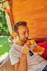 Fototapeta premium Man drinking coffee on a home porch.