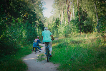 active senior grandmother with kids riding bikes in nature