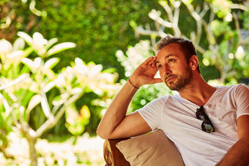 Man thinking while sitting on a porch sofa.