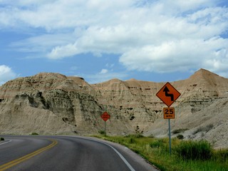 Road signs warning motorists of a curve and dangerous fallen rocks