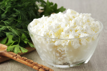 A bowl with cottage cheese and a bunch of green