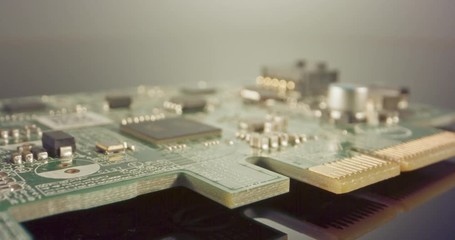 Extreme macro dolly shot of a PCB computer board with capacitors and transistors