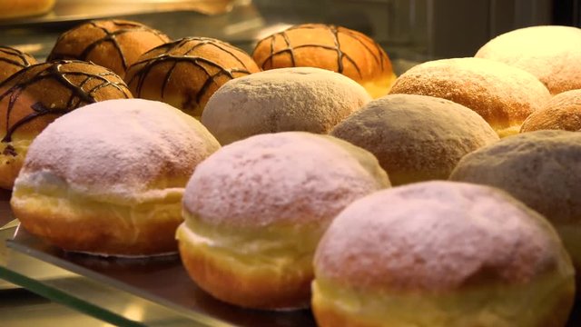 Closeup on Berliner doughnuts on display on a glass shelf in a bakery