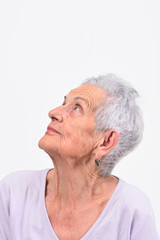 portrait of senior woman looking up on white background