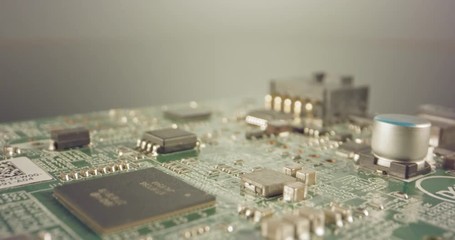 Extreme macro dolly shot of a PCB computer board with capacitors and transistors