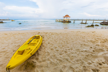 Yellow kayak boat on white sand beach