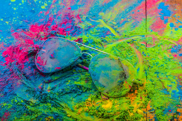 Holi color powder on sunglasses. Organic Gulal colours on eyeglasses for Holi festival, Hindu tradition festive