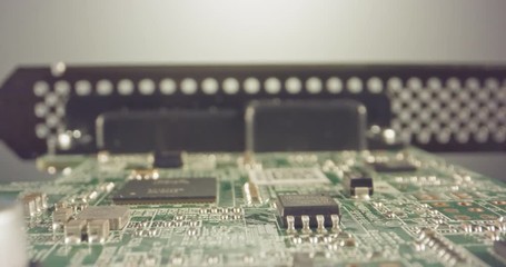 Extreme macro dolly shot of a PCB computer board with capacitors and transistors