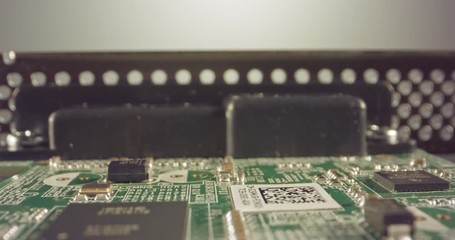 Extreme macro dolly shot of a PCB computer board with capacitors and transistors