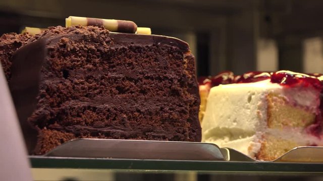 Closeup on various slices of cakes on display in a store
