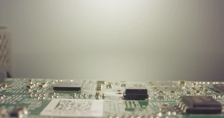 Extreme macro dolly shot of a PCB computer board with capacitors and transistors