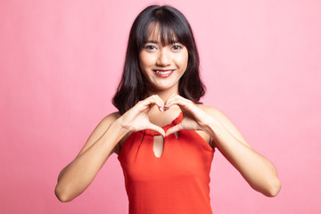 Young Asian woman show heart hand sign.