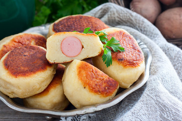 Sausage in potato dough on a metal dish, selective focus
