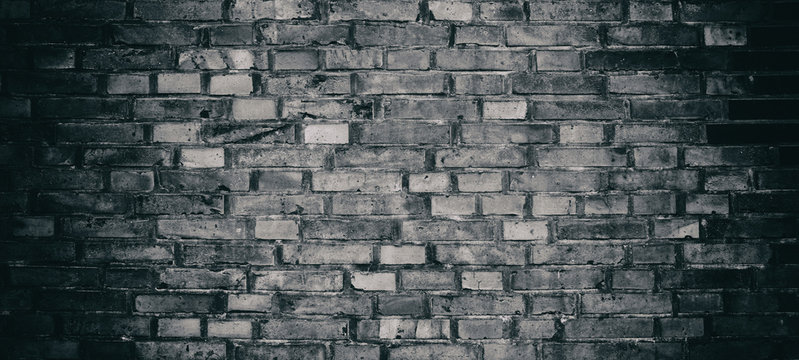 Abstract black brick wall pattern background. Rough texture and grunge surface backdrop for architecture decoration interior. High resolution panoramic abstract black brick background