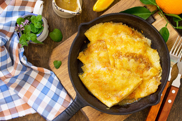 Homemade French pancakes - Crepe Suzette with orange syrup for a delicious breakfast. Top view flat...