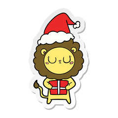 sticker cartoon of a lion with christmas present wearing santa hat