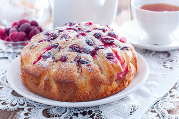 Homemade pie with cranberries and apples on a white napkin, horizontal
