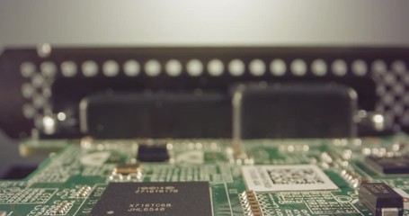 Extreme macro dolly shot of a PCB computer board with capacitors and transistors