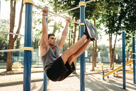 Man doing exercise on press using horizontal bar