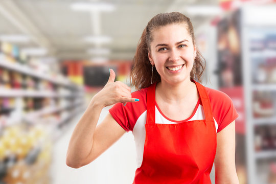 Store manager making call us gesture.