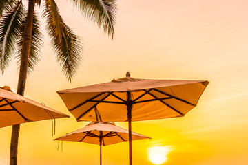 Umbrella and chair on the beautiful beach and sea at sunrise time for travel and vacation