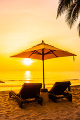 Umbrella and chair on the beautiful beach and sea at sunrise time for travel and vacation