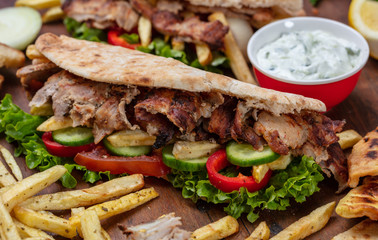 Gyros, shawarma, take away, street food.  Sandwich with meat on wooden table