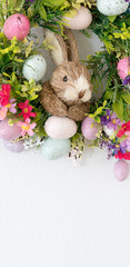 easter wreath with colorful eggs and flowers and a rabbit in the center