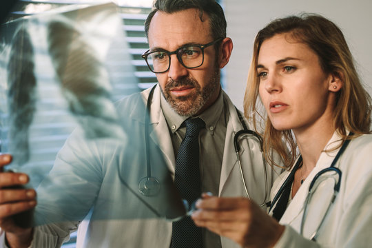 Doctor and surgeon closely studying x-ray of patient