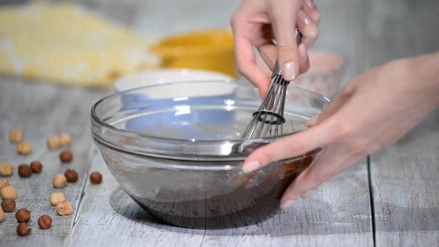 Making chocolate dessert. Preparing for baking brownie cake. Add the eggs to the batter.