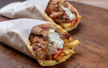Gyro pita, shawarma, take away, street food. Traditional greek turkish, meat food on wooden table