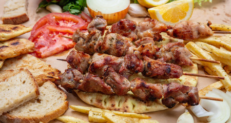 Souvlaki, meat skewers, traditional greek turkish meat food on pita bread, tzatziki sauce and potatoes
